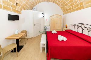 a bedroom with a red bed with two white towels on it at Casa di Ponente - Gallipoli in Gallipoli