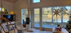 a living room with a christmas tree and a large window at Levi Lakeview Ahvenranta in Kittilä