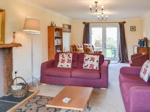 a living room with a purple couch and a table at Sand Castles in Seahouses