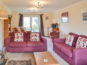 a living room with two purple couches and a table at Sand Castles in Seahouses
