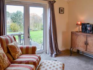 a living room with a couch and a sliding glass door at Sand Castles in Seahouses