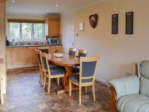 a kitchen and dining room with a wooden table and chairs at Sand Castles in Seahouses +12 photos
