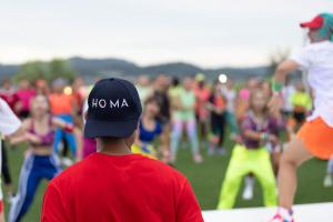 a man in a hat watching a group of people dancing at HOMA Cherngtalay Phuket in Bang Tao Beach