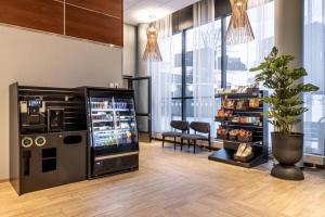 a store with a refrigerator and a plant in a room at Scandic Postitalo in Tampere