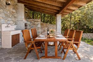 a wooden table and chairs on a patio at Altamarea Private Retreat in Corniglia