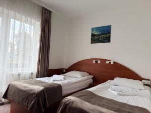 a hotel room with two beds and a window at Hotel Sjesta in Mikołów