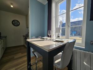 a kitchen with a table with two chairs and a window at Étretat, Alphonse Karr in Étretat +9 photos