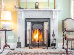 a fireplace in a living room with a mantle at Ladywell House in Falkland