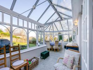 a conservatory with a glass roof with a table and chairs at Ladywell House in Falkland