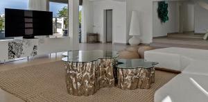 a living room with two tables and a flat screen tv at Super views in Mykonos in Psarou