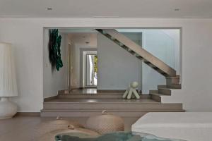 a living room with a mirror and a staircase at Super views in Mykonos in Psarou