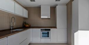 a kitchen with white cabinets and a sink at Super views in Mykonos in Psarou +2 photos