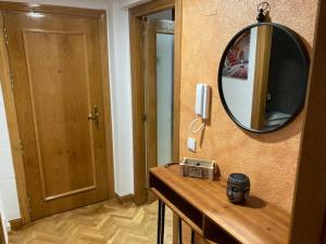 a mirror on a wall next to a room with a table at Dúplex céntrico La Ranita Salmantina in Salamanca