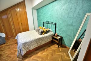 a bedroom with a bed and a green wall at Dúplex céntrico La Ranita Salmantina in Salamanca +24 photos