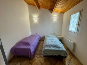 a room with two beds with purple sheets in it at La Canotière in Saint-Georges-dʼOléron