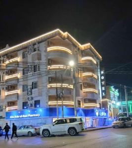 a building with cars parked in front of it at night at flamingo hotel irbid in Zabdah