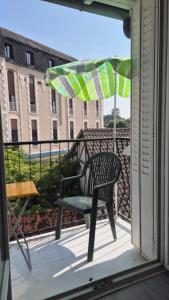 a chair sitting on a balcony with an umbrella at Le sélect in Néris-les-Bains