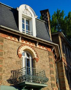 a building with a window with a clock on it at Hotel du Parc in Dinard