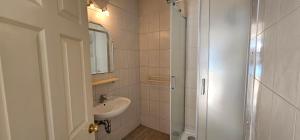 a bathroom with a sink and a shower at Beach front with Swimming pool, Illyria Resort Apt 101 in Milna