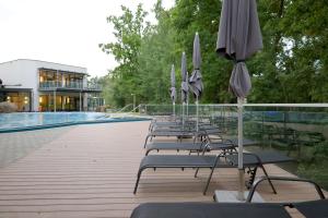 a row of chairs with umbrellas next to a pool at Hotel Sole Felsen Welt in Gmünd