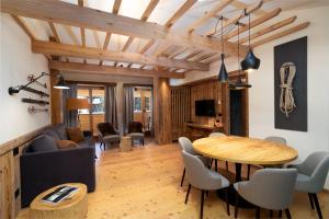 a living room with a wooden table and a dining room at Breithorn Lodge in Champoluc