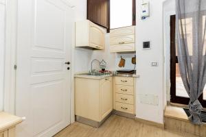 a small kitchen with white cabinets and a sink at Casa di Levante - Gallipoli in Gallipoli +4 photos