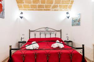 a red bed with a dog laying on it at Casa di Levante - Gallipoli in Gallipoli