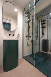 a bathroom with a glass shower and a mirror at The Place in Milan +30 photos