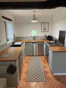 a kitchen with stainless steel appliances and wooden counter tops at Le Grand Chene in Moustier