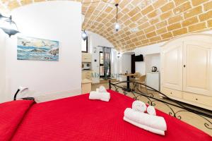 a bedroom with a red bed with towels on it at Casa di Levante - Gallipoli in Gallipoli