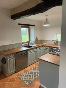 a large kitchen with gray cabinets and a window at Le Grand Chene in Moustier