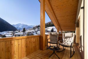 two chairs on a balcony with a view at Breithorn Lodge in Champoluc