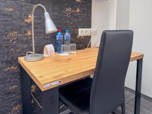 a desk with a lamp and water bottles on it at Hotel Sjesta in Mikołów