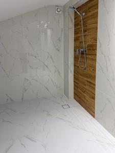 a bathroom with a shower with white marble walls at Hotel Sjesta in Mikołów +25 photos