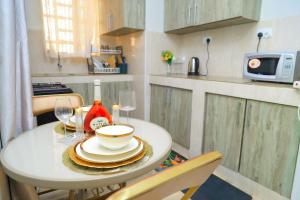 a small white table with plates and wine glasses at Graphite & Gold Suite in Ruiru
