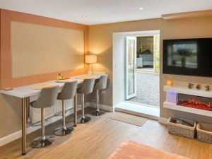 a living room with two bar stools and a tv at Pasture Barn in Barnard Castle