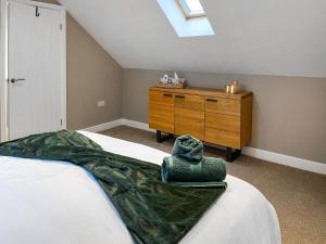 a bedroom with a bed and a wooden dresser at Pasture Barn in Barnard Castle
