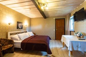 a bedroom with a bed and a chair and a television at Hämsa Maheresto & Heaolukeskus in Võru