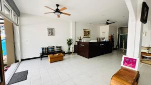 a living room with a ceiling fan and a couch at Oh'tel Kata in Kata Beach
