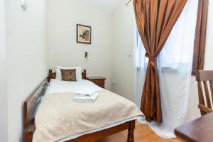a small bedroom with a bed and a window at DOWNTOWN ROOMS in Niš +66 photos