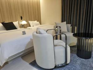 a hotel room with two beds and two chairs at Hotel Signature Gwangju in Gwangju