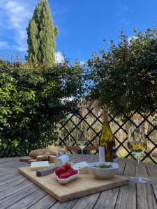 a wooden table with a bottle of wine and cheese at Guest House, Private Pool in LʼIsle-en-Dodon