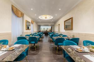 a dining room with tables and blue chairs at Hotel Raffaello - Sure Hotel Collection by Best Western in Rome +54 photos