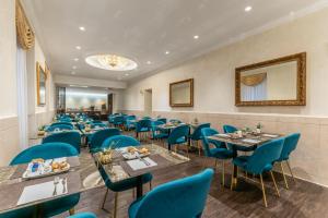 a dining room with blue chairs and tables at Hotel Raffaello - Sure Hotel Collection by Best Western in Rome