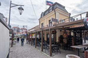 a group of buildings on a street with tables and chairs at DOWNTOWN ROOMS in Niš