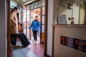 a woman walking through a door with a suitcase at DOWNTOWN ROOMS in Niš
