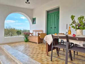 a living room with a green door and a table and chairs at Abaton - Casa vacanza in Metaponto