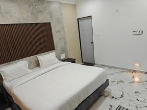 a bedroom with a large white bed with marble floors at The Ooty Suites in Ooty +7 photos