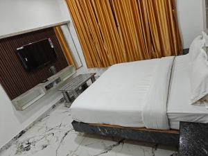a bedroom with a bed and a window and a table at The Ooty Suites in Ooty