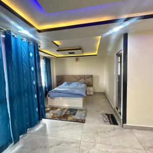 a bedroom with a bed and blue curtains at A Cube Homestay in Bharatpur
